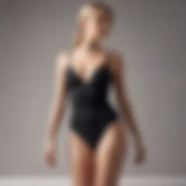 Elegant black spaghetti strap bathing suit displayed against a minimalist backdrop